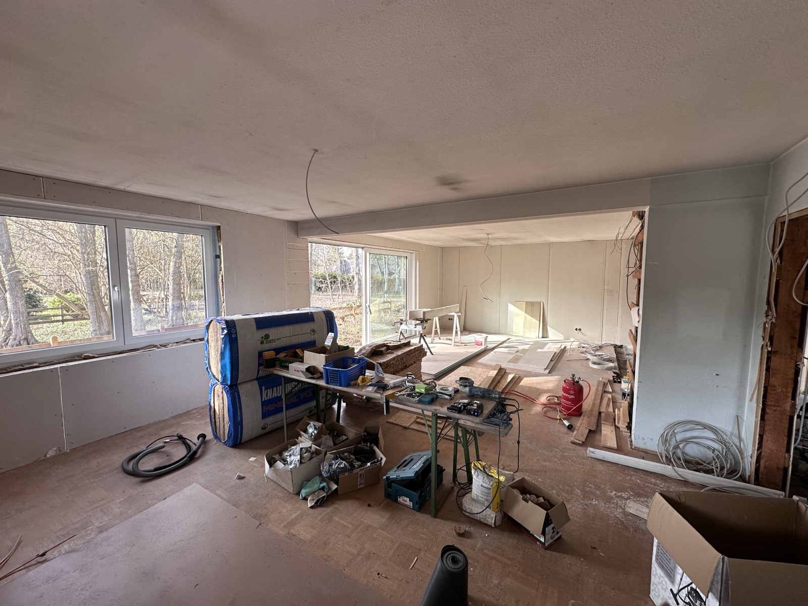 Rohbau eines Wohnzimmers mit Baumaterial vor der Visualisierung
